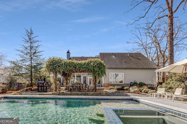 view of pool featuring a pool with connected hot tub and a patio