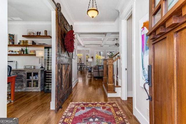 foyer entrance featuring stairway, a barn door, wood finished floors, coffered ceiling, and beamed ceiling