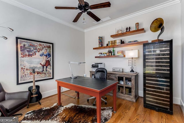 office area featuring crown molding, ceiling fan, wood finished floors, beverage cooler, and baseboards