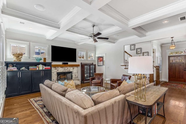 living area with wood-type flooring, stairs, coffered ceiling, and beamed ceiling