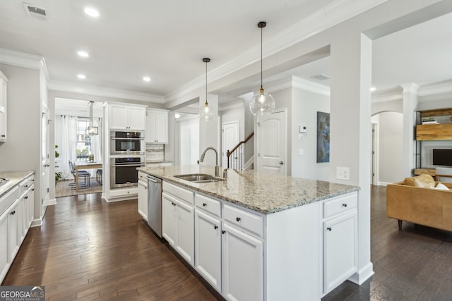 kitchen featuring appliances with stainless steel finishes, ornamental molding, dark wood-type flooring, white cabinetry, and a sink