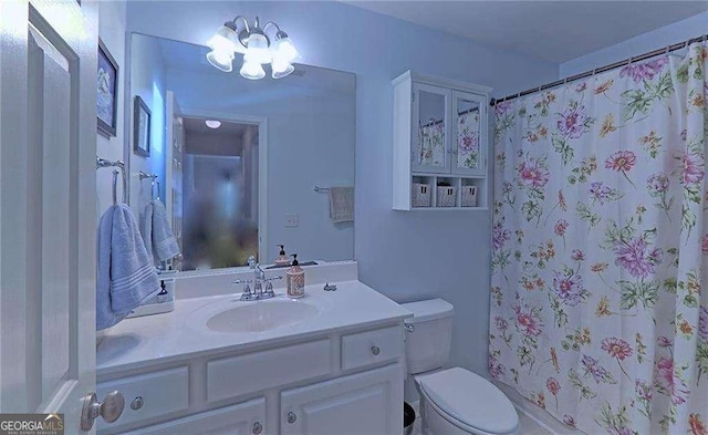 full bath featuring curtained shower, vanity, and toilet