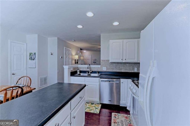 kitchen featuring dark countertops, visible vents, stainless steel dishwasher, white cabinetry, and a sink