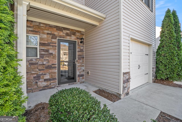 entrance to property featuring stone siding and an attached garage