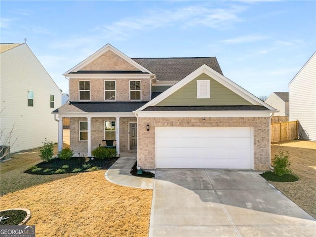 traditional home with a garage, concrete driveway, brick siding, and fence