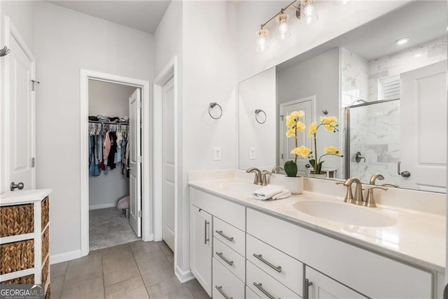 bathroom featuring a stall shower, tile patterned flooring, a sink, and double vanity