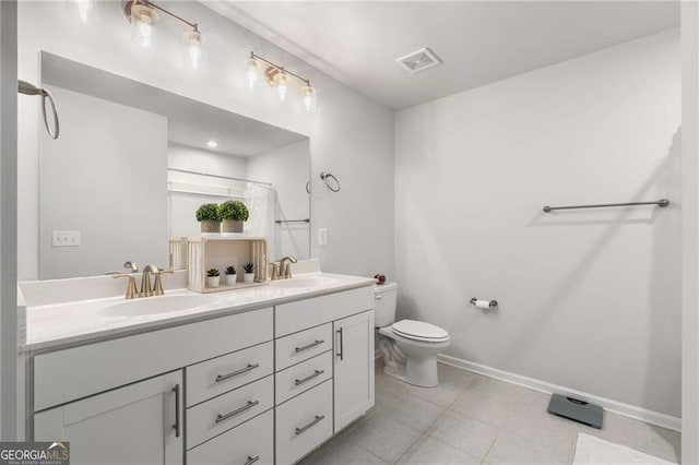 bathroom with toilet, double vanity, a sink, and visible vents