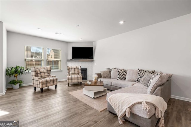 living room featuring a fireplace, wood finished floors, and baseboards