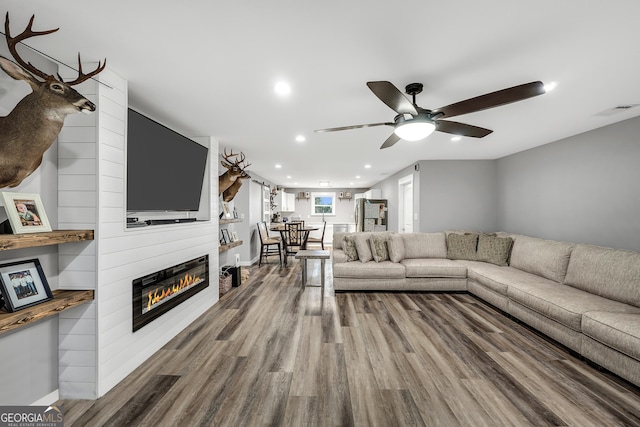 living area with a large fireplace, visible vents, a ceiling fan, wood finished floors, and recessed lighting