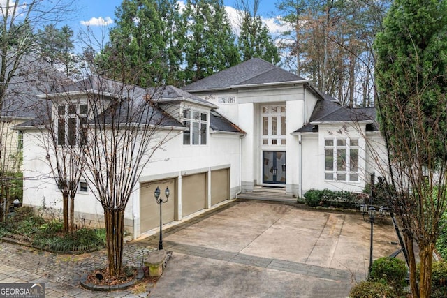 view of front of home featuring a shingled roof, french doors, driveway, and stucco siding