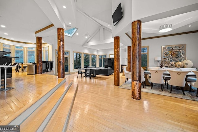 game room with high vaulted ceiling, wood-type flooring, beam ceiling, and ornate columns