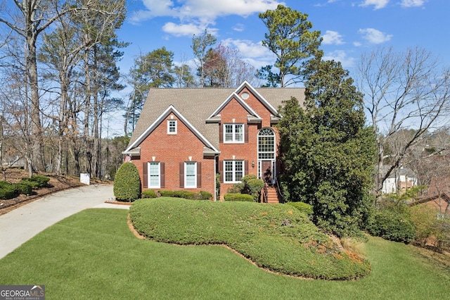 traditional home featuring brick siding and a front yard