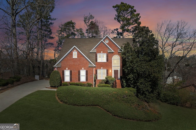 view of front of home with a front lawn and brick siding