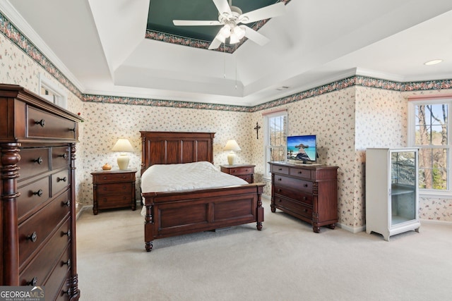 bedroom with a tray ceiling, ornamental molding, light carpet, baseboards, and wallpapered walls