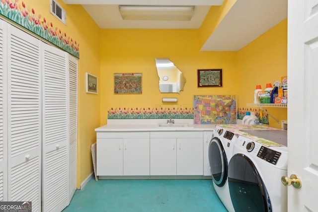 washroom with cabinet space, visible vents, a sink, and washing machine and clothes dryer