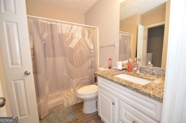 full bath with toilet, a shower with curtain, wood finished floors, and vanity