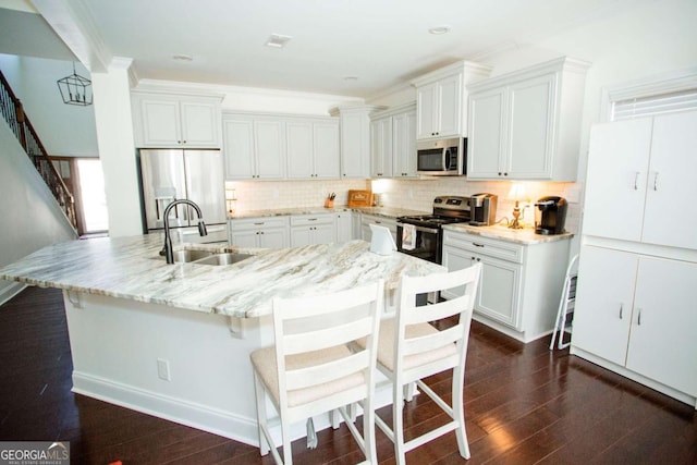 kitchen featuring appliances with stainless steel finishes, dark wood-type flooring, a sink, and backsplash