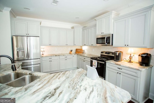 kitchen featuring tasteful backsplash, visible vents, stainless steel appliances, crown molding, and a sink