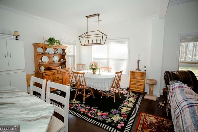 dining space with baseboards, ornamental molding, and wood finished floors