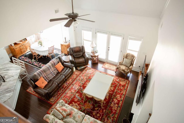 living area featuring high vaulted ceiling, visible vents, and wood finished floors