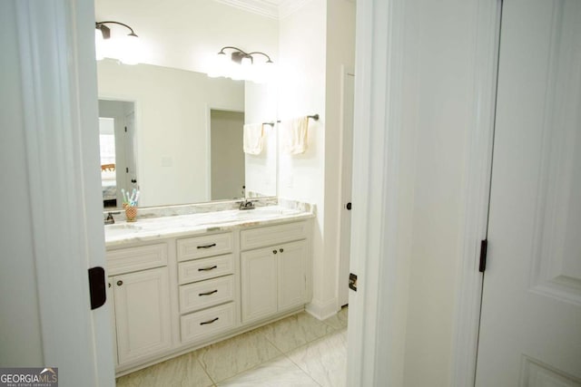 full bathroom with marble finish floor, double vanity, a sink, and crown molding