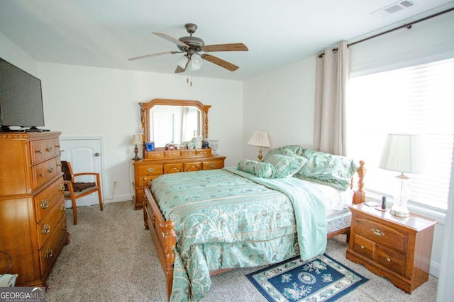 bedroom with a ceiling fan, visible vents, and light colored carpet