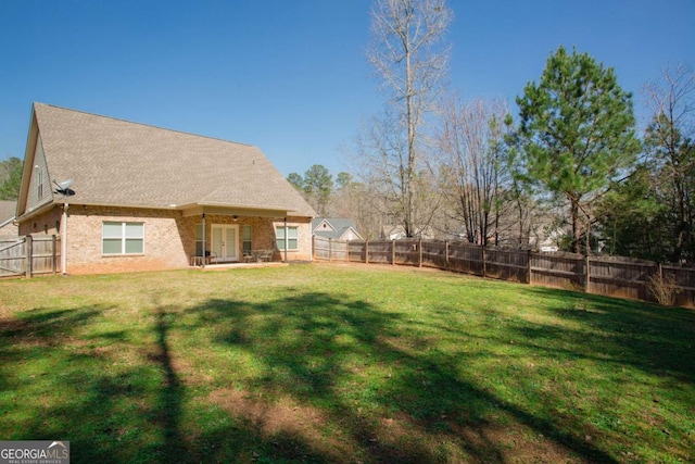 view of yard with a patio area, french doors, and a fenced backyard