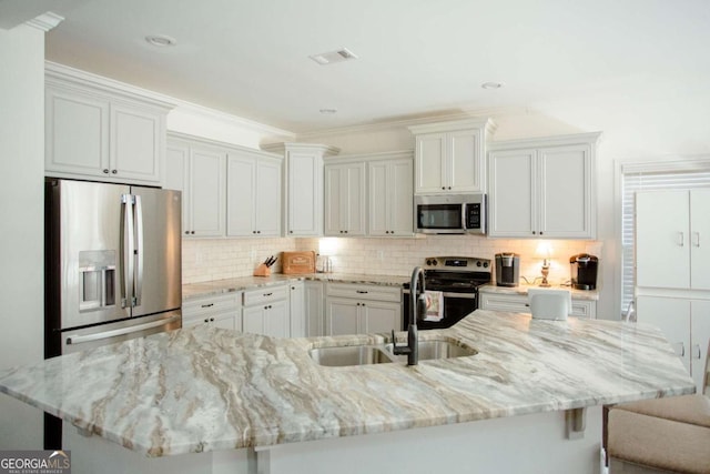 kitchen featuring visible vents, appliances with stainless steel finishes, backsplash, and a sink