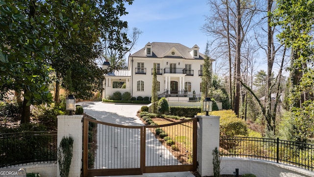 view of front facade featuring a fenced front yard, a gate, and a balcony