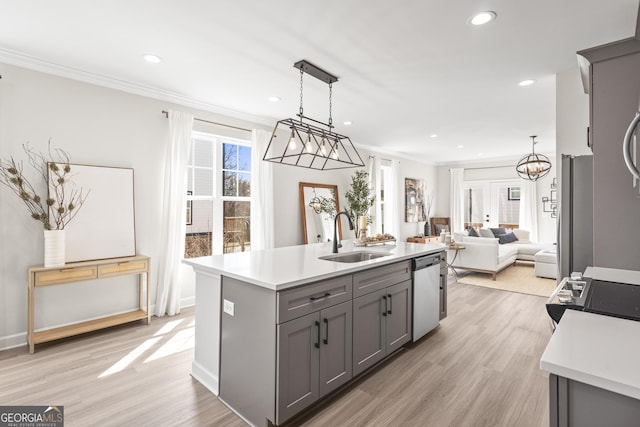 kitchen with light countertops, appliances with stainless steel finishes, a sink, and gray cabinetry