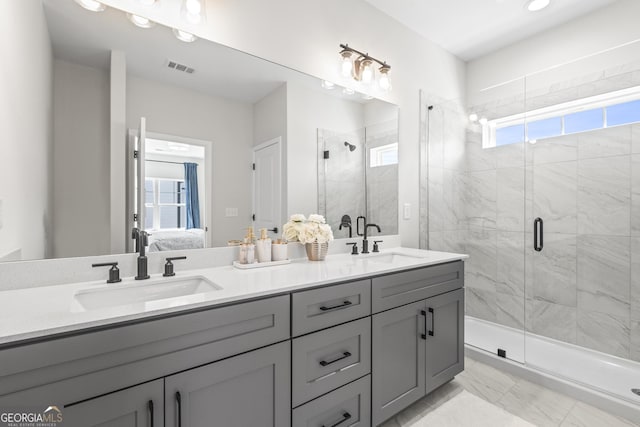 ensuite bathroom with ensuite bathroom, double vanity, a stall shower, and a sink