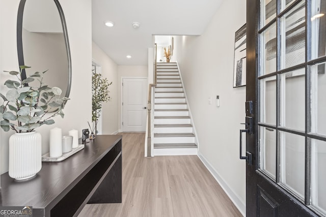 foyer featuring light wood-style floors, recessed lighting, baseboards, and stairs