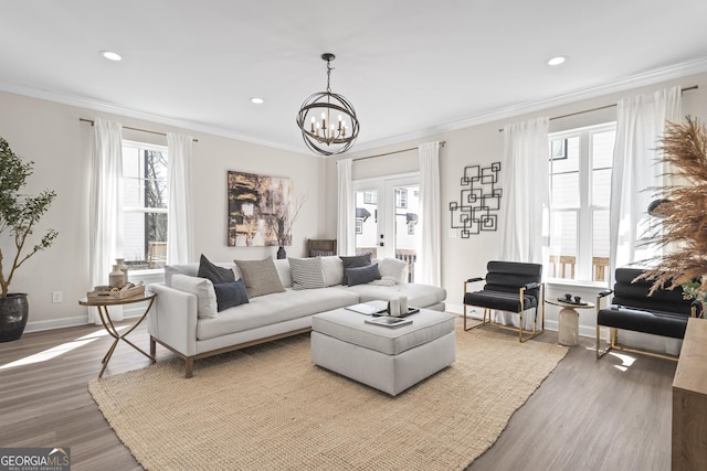 living area featuring crown molding, recessed lighting, an inviting chandelier, wood finished floors, and baseboards