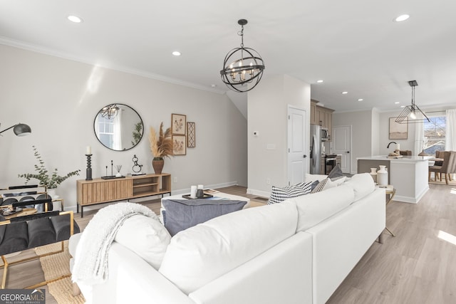 living area featuring light wood finished floors, an inviting chandelier, recessed lighting, and crown molding