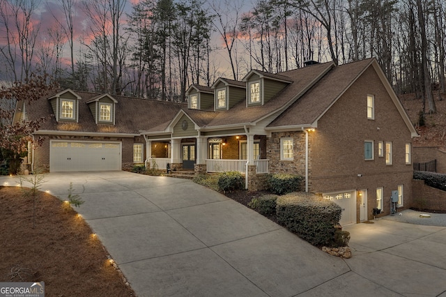 cape cod home with driveway, a porch, and brick siding