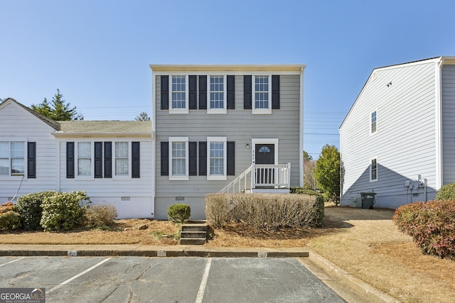 view of front of house with crawl space and uncovered parking