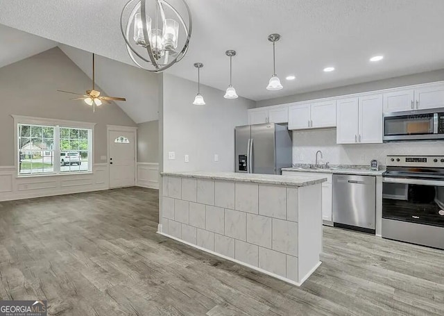 kitchen with appliances with stainless steel finishes, wainscoting, light wood-style flooring, and white cabinets