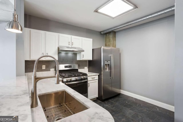 kitchen with appliances with stainless steel finishes, white cabinets, a sink, and under cabinet range hood