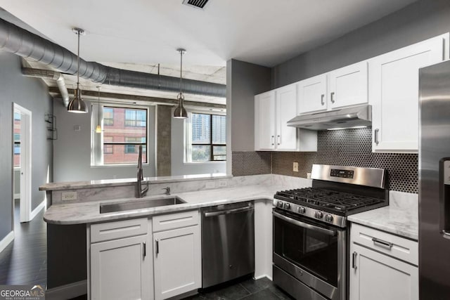 kitchen with white cabinets, a peninsula, stainless steel appliances, under cabinet range hood, and a sink