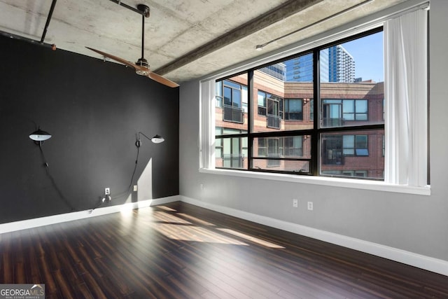 empty room featuring baseboards and wood finished floors