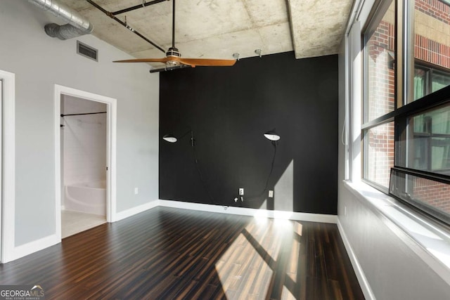 unfurnished room featuring a ceiling fan, baseboards, visible vents, and wood finished floors