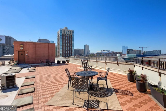 view of patio / terrace featuring cooling unit and a city view