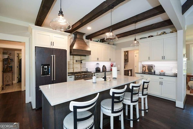 kitchen featuring premium range hood, white cabinets, and premium appliances