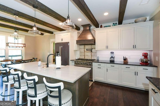 kitchen with a breakfast bar, white cabinetry, custom exhaust hood, tasteful backsplash, and high end appliances