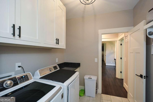 laundry room with cabinet space, washer and clothes dryer, baseboards, and light tile patterned floors