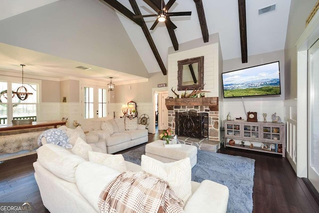 living room featuring visible vents, wainscoting, wood-type flooring, beamed ceiling, and a fireplace