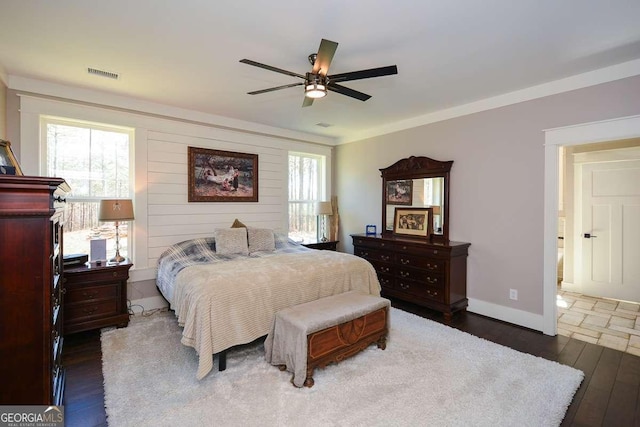 bedroom featuring baseboards, visible vents, multiple windows, and hardwood / wood-style flooring