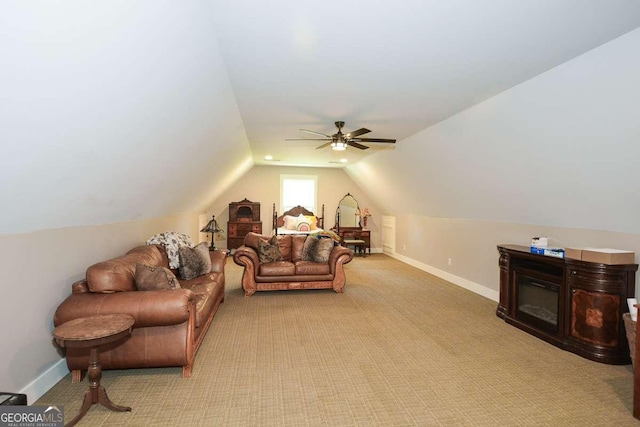 interior space with light carpet, baseboards, vaulted ceiling, and a ceiling fan