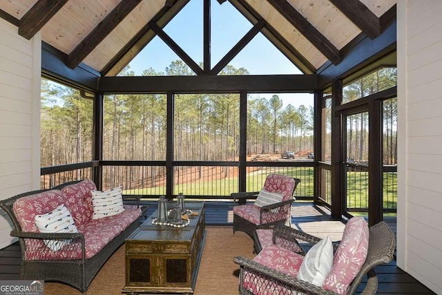 sunroom featuring lofted ceiling with beams