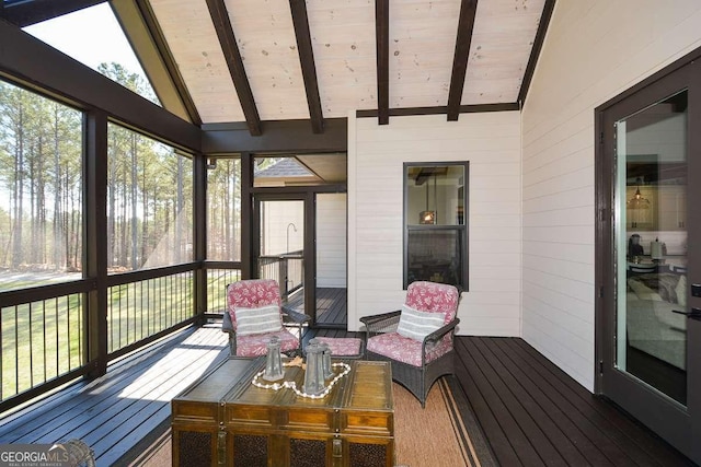 sunroom / solarium with wooden ceiling, plenty of natural light, and lofted ceiling with beams